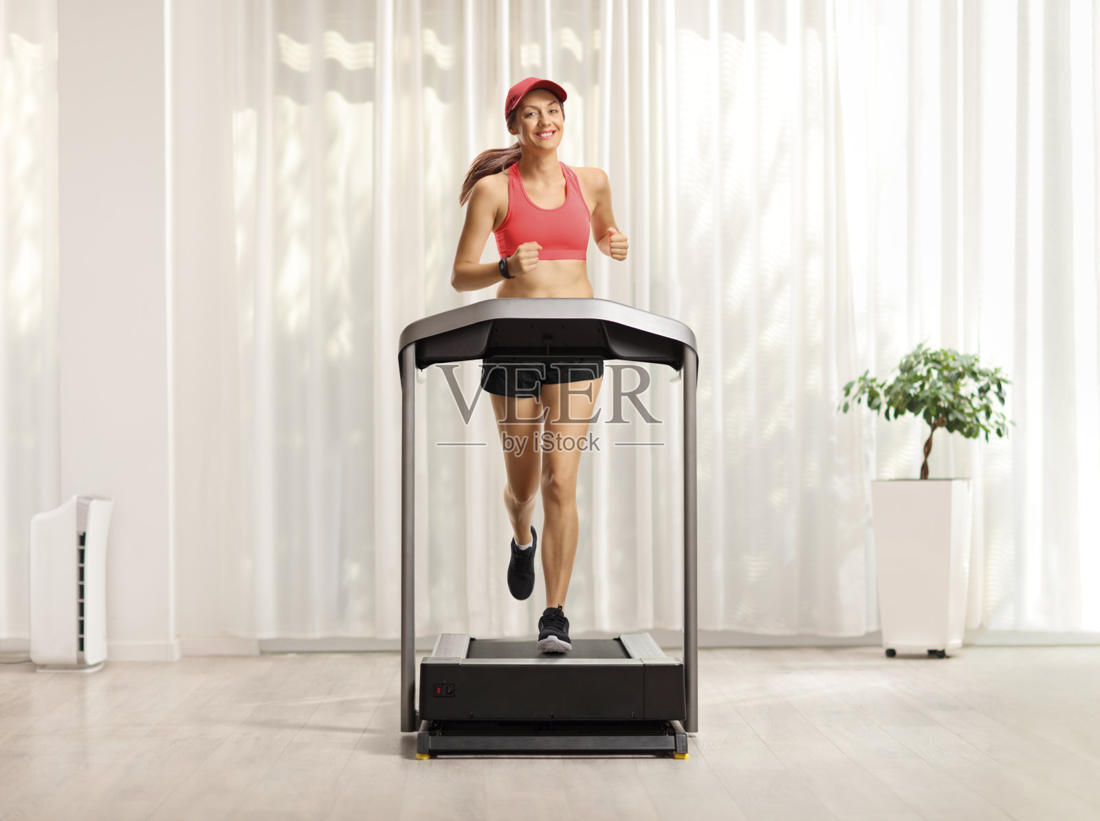 在家里跑步机上跑步的年轻女子照片摄影图片