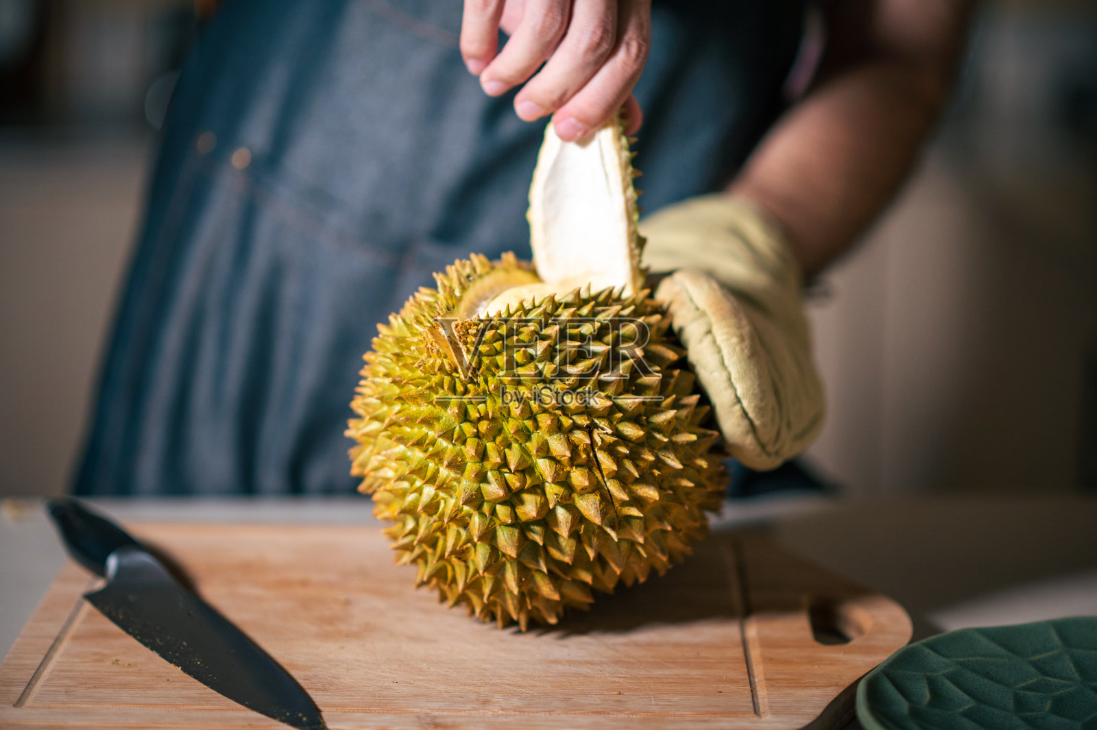 有人在家里厨房的砧板上打开泰国热带水果榴莲照片摄影图片