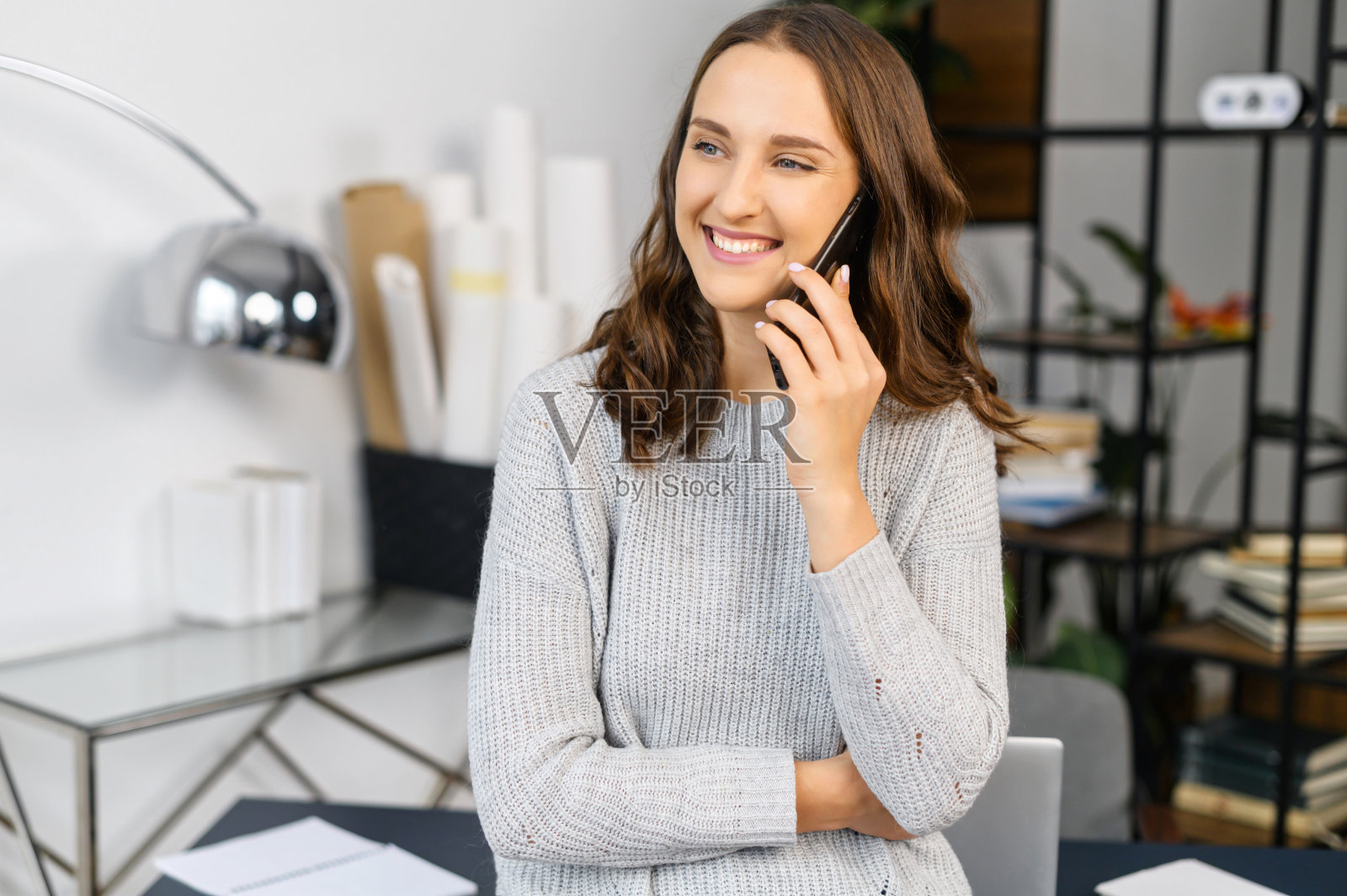 微笑的女人说着电话,看着镜头照片摄影图片