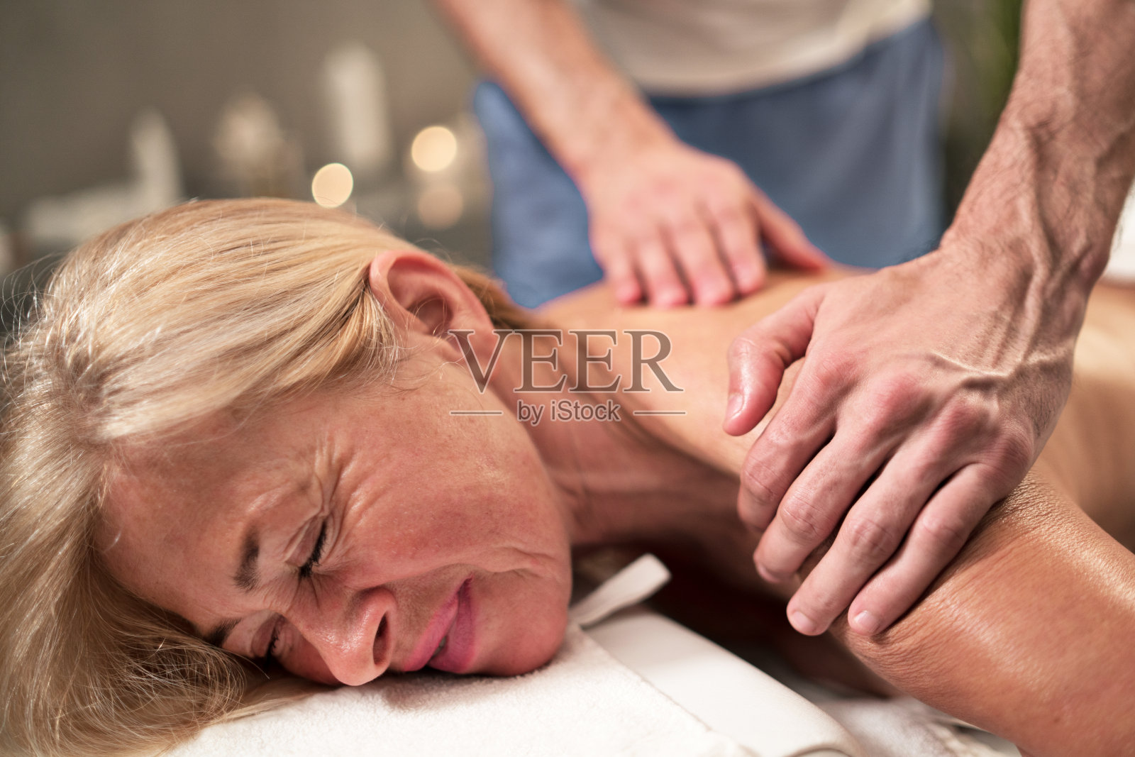 老女人在水疗中心做背部按摩。照片摄影图片