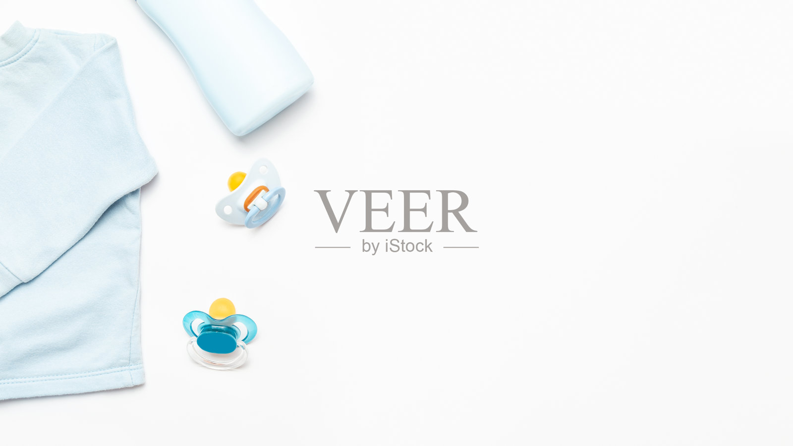 孩子出生的概念。新生儿的配件和衣服。蓝色婴儿衬衫和乳头在白色的背景。婴儿洗澡。前视图。空间的文本。照片摄影图片