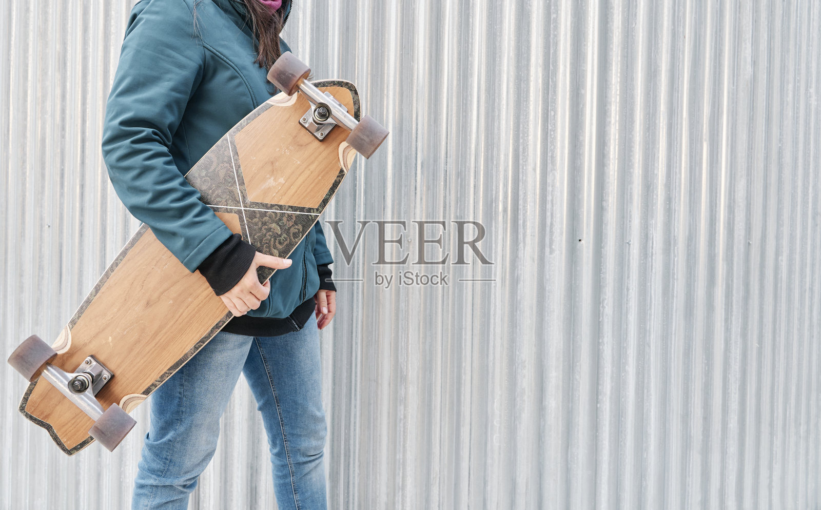 拿着滑板的无名小女孩。为文本复制空间。可持续的交通理念和健康的生活方式。照片摄影图片