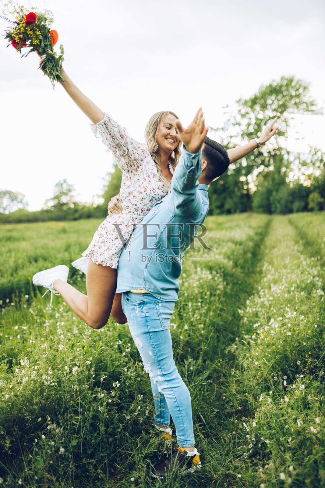 爱在空气中,年轻夫妇在大自然中展示他们的爱。照片摄影图片