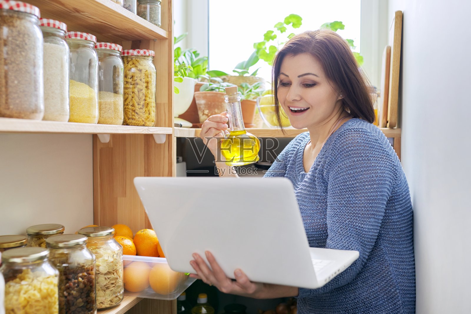 家庭餐具室厨房内部,女人用笔记本记录视频,存储组织照片摄影图片