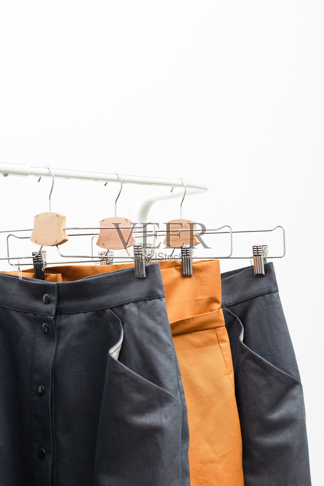 衣服挂在衣架上,以白色为背景照片摄影图片