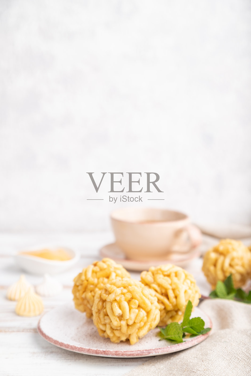 传统的鞑靼糖果chakk -chak由面团和蜂蜜与一杯咖啡在白色的木制背景和亚麻纺织。侧视图,拷贝空间,选择性焦点。照片摄影图片