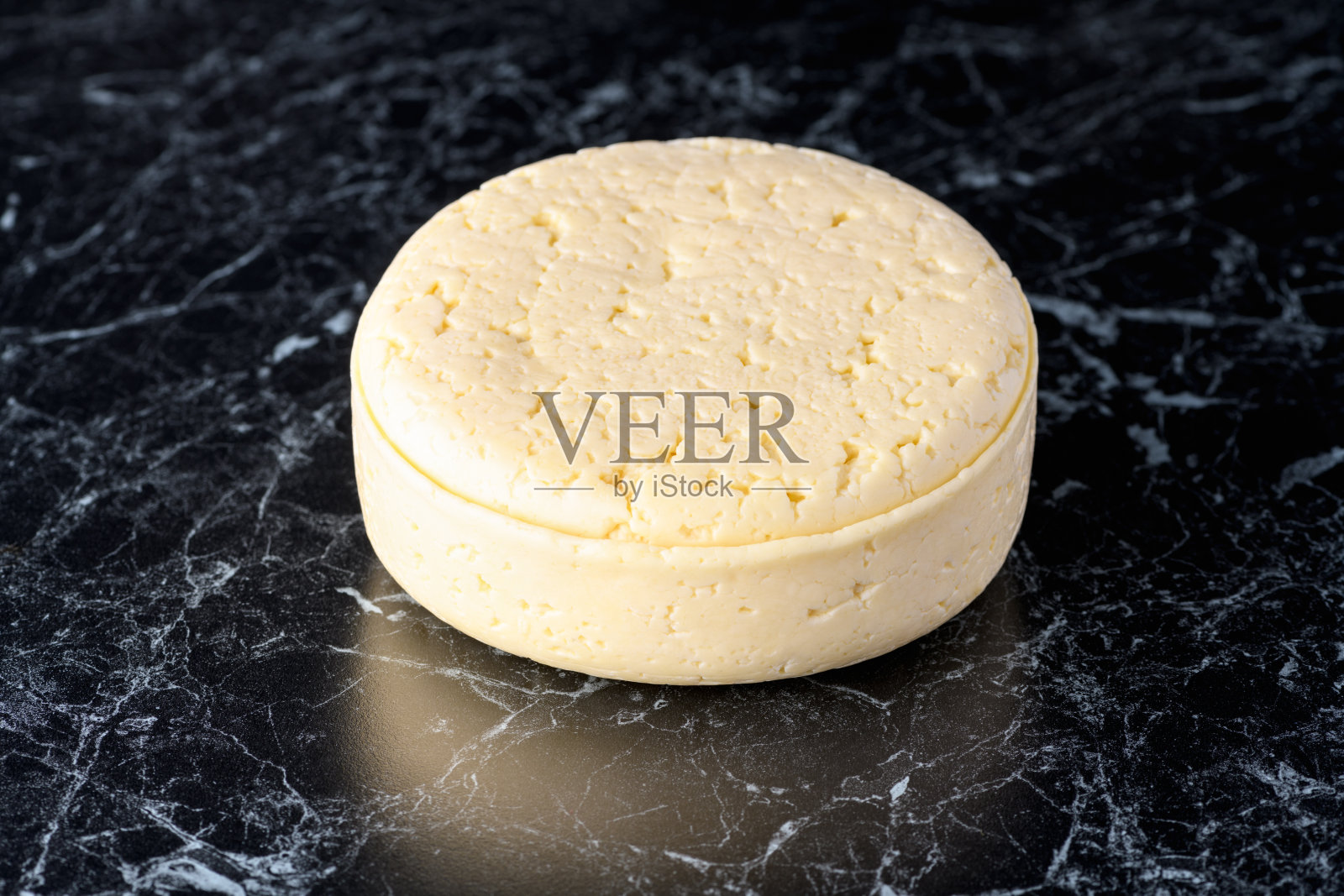 黑色背景上的奶酪整个头部。自制的产品照片摄影图片