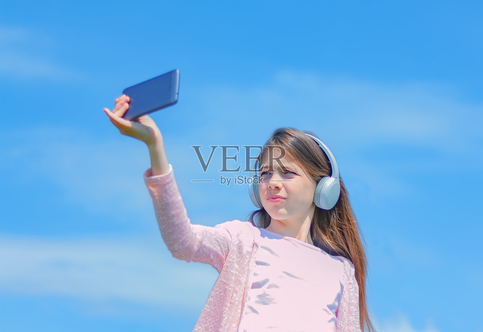 少女戴着耳机看智能手机照片摄影图片