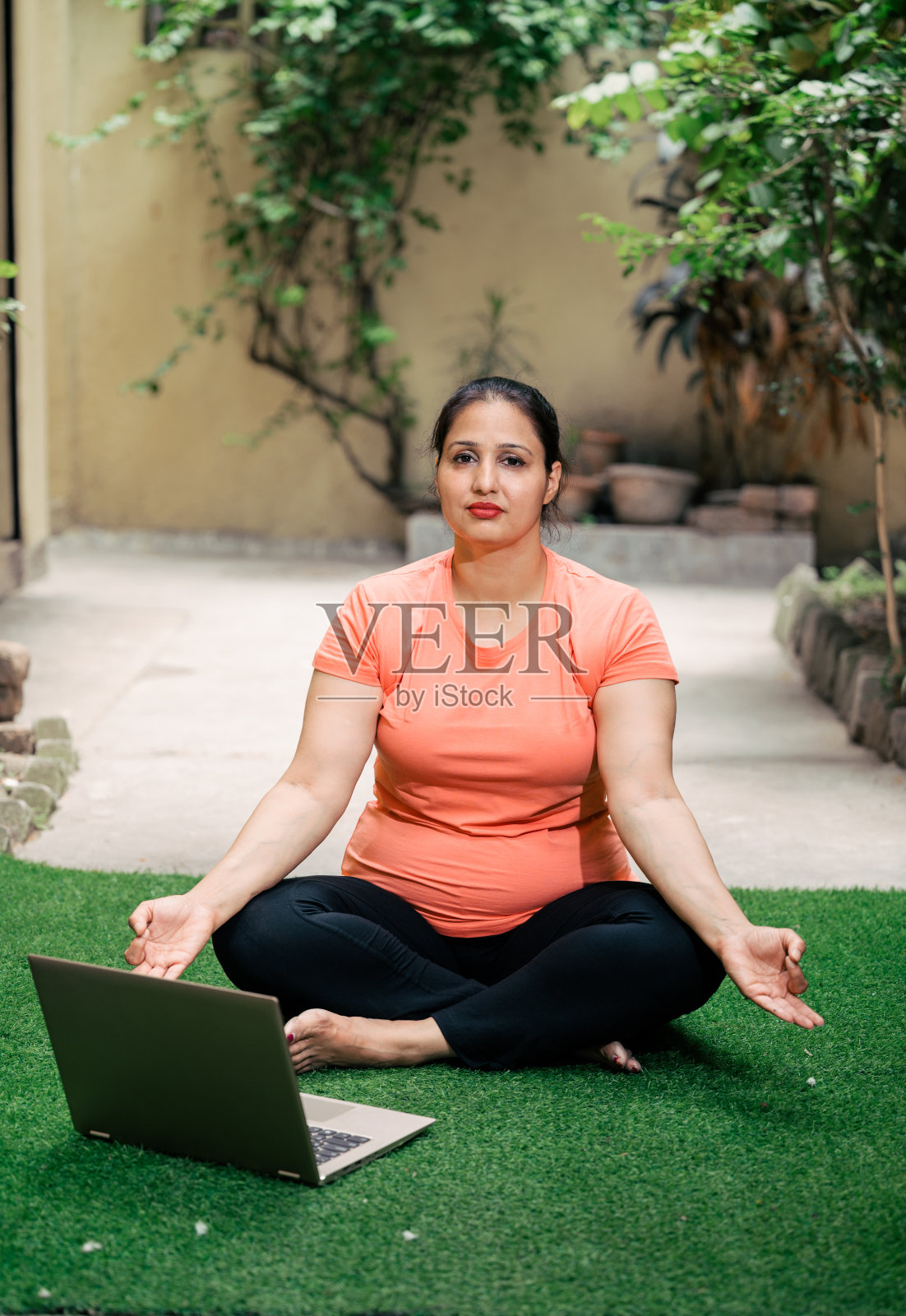 在线健身训练,资深女性在家用笔记本做瑜伽。照片摄影图片