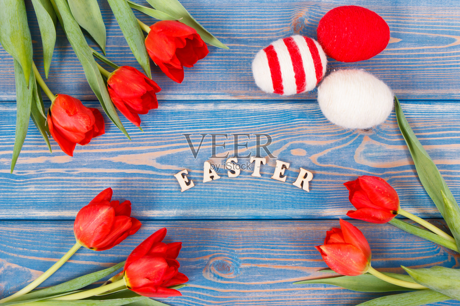 题字复活节,用红郁金香和毛线把鸡蛋裹在木板上,装饰节日照片摄影图片