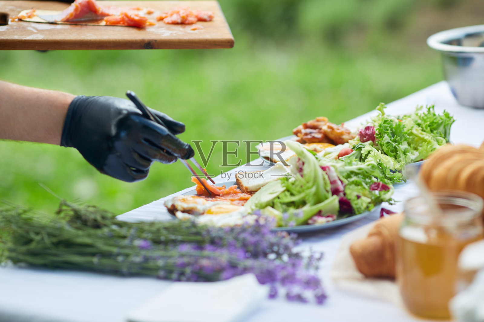 厨师用镊子夹三文鱼。照片摄影图片