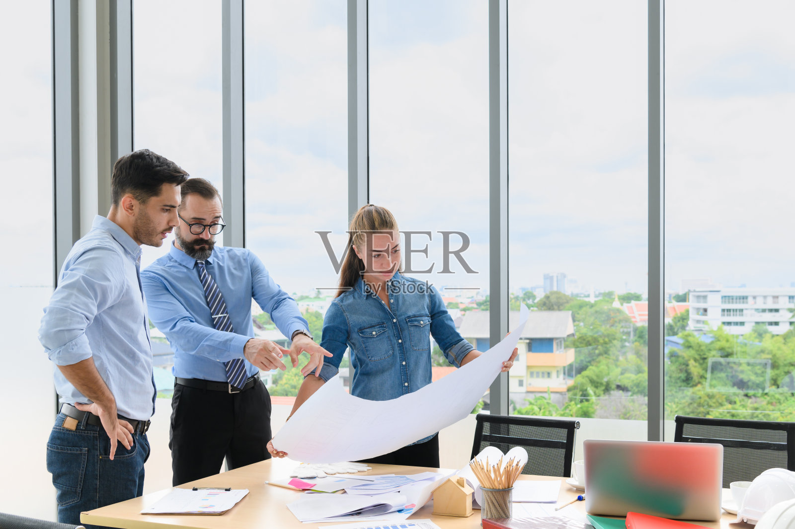 建筑项目工程师团队会议。建筑师与施工经理在办公室工人会议现场讨论蓝图。建筑的概念照片摄影图片