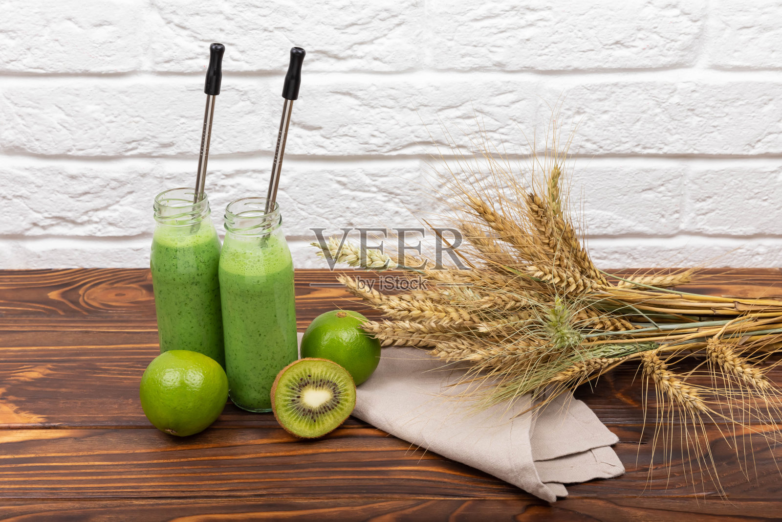 木桌子上放着冰沙汁和麦片。菠菜绿色奶昔照片摄影图片