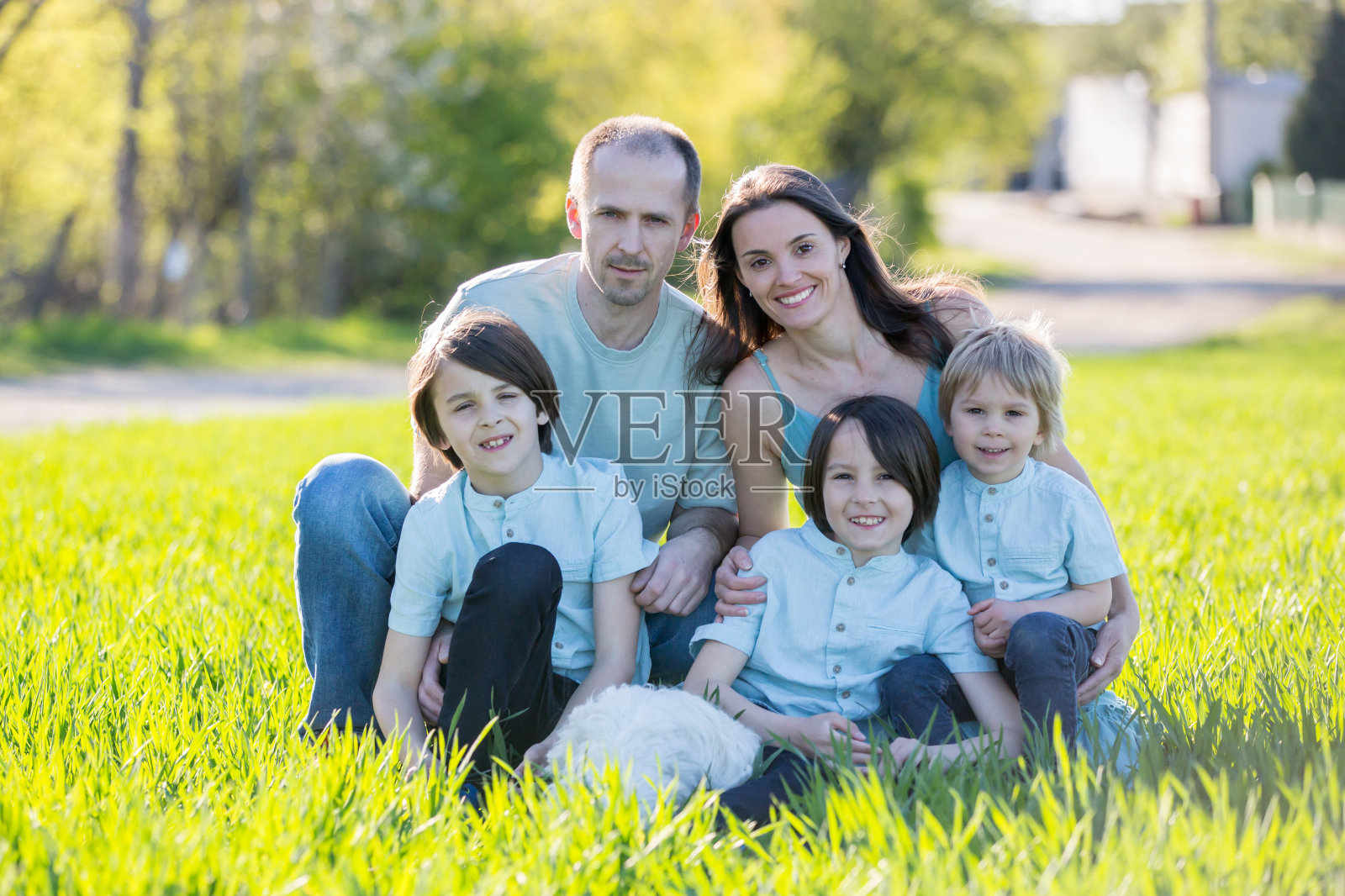 美丽的家庭,有孩子们,妈妈,爸爸,三个男孩和一只狗,在公园里玩照片摄影图片