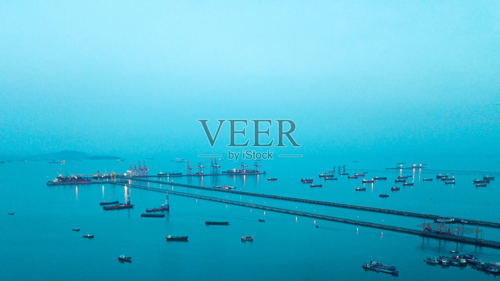 鸟瞰图,码头到吊车桥正在船厂夜间将集装箱货物卸给船舶照片摄影图片