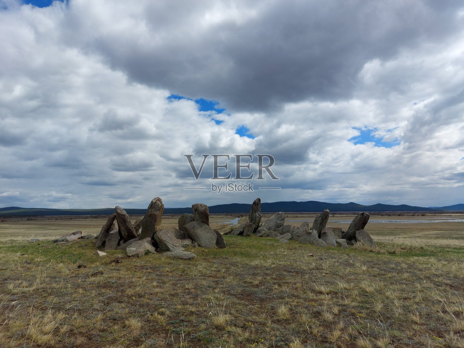 古坟堆下的墓石阴天碧蓝。俄罗斯远东,布里亚特照片摄影图片