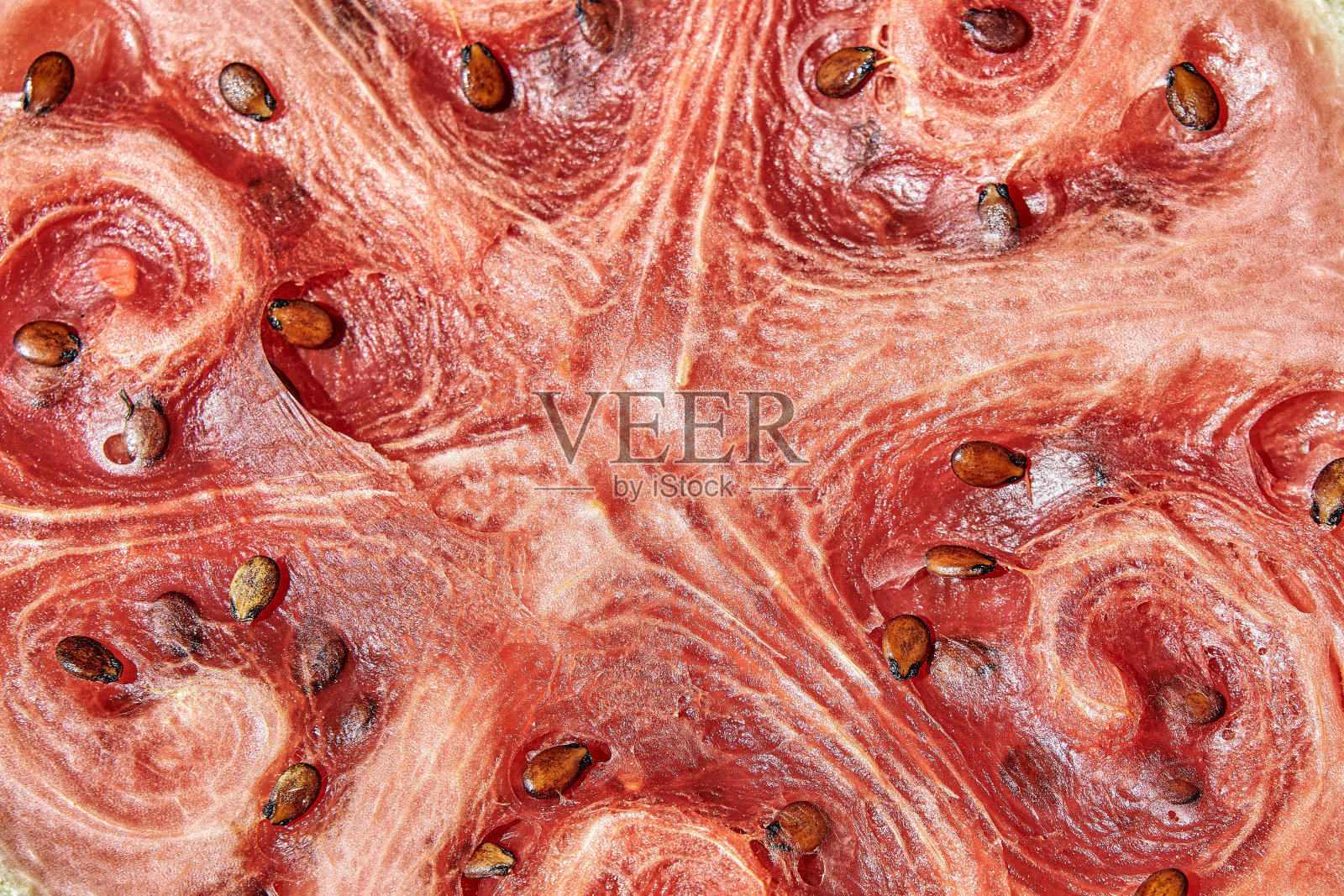 一半熟透的西瓜,表面干燥,种子放在桌上照片摄影图片