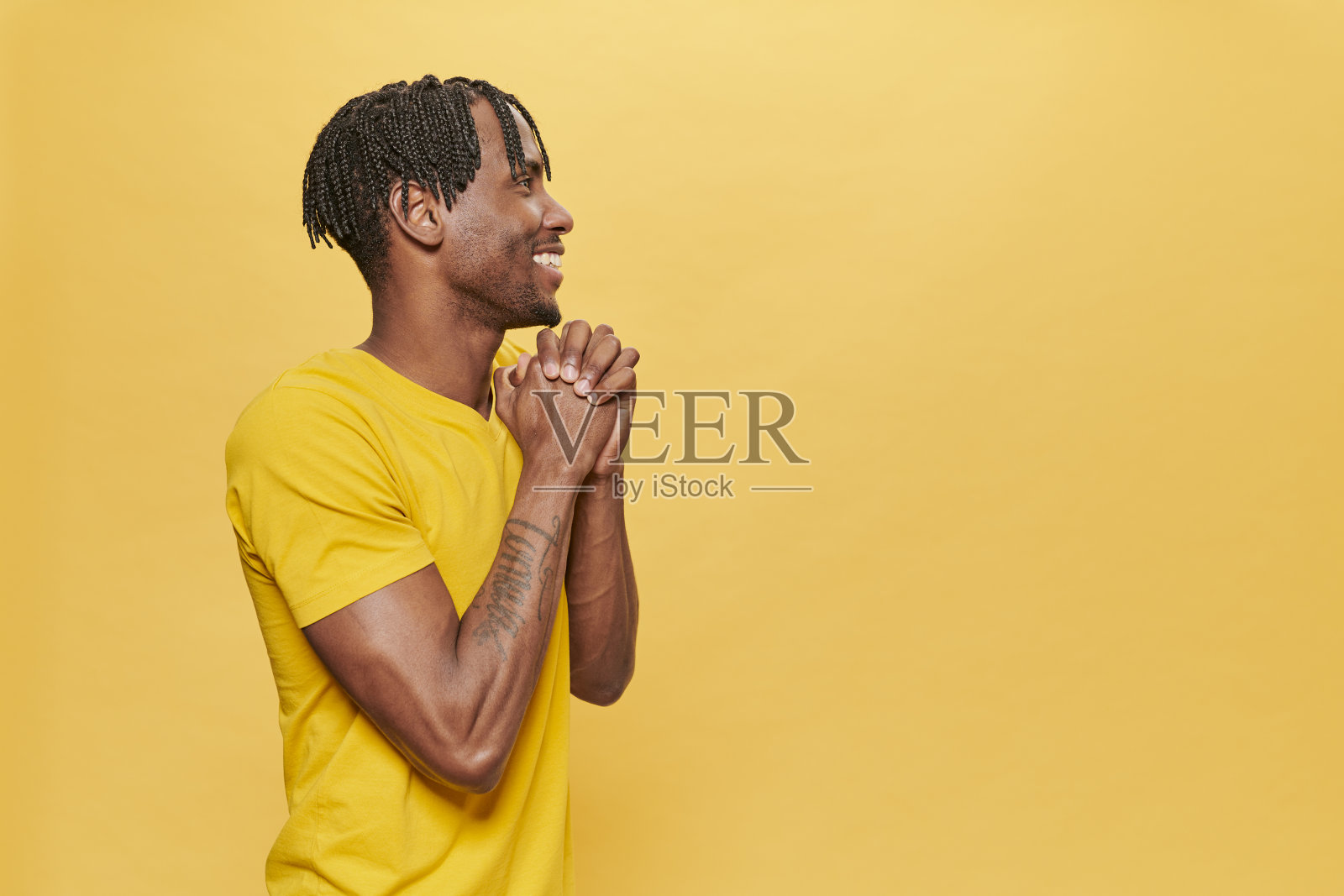 英俊的非洲男子在黄色背景穿着黄色t恤照片摄影图片