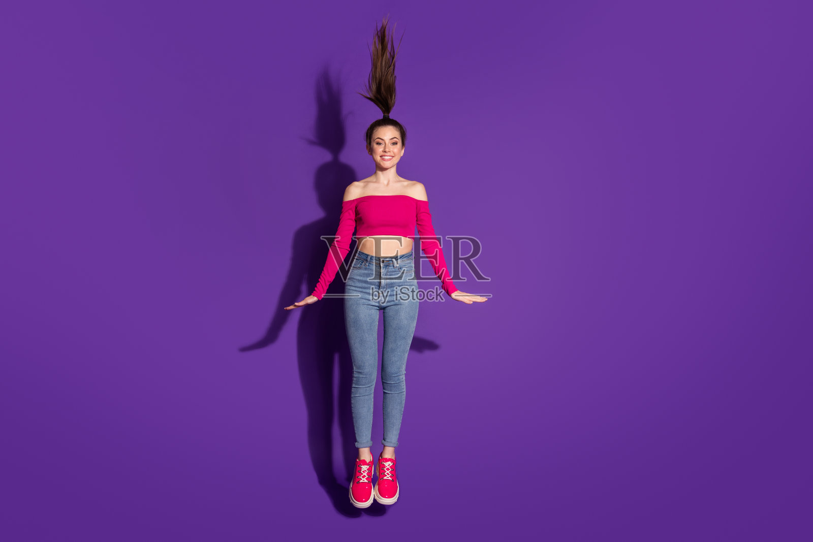 迷人的,活泼的,时髦的,害羞的,苗条的女孩的全长身体尺寸视图跳有乐趣孤立明亮的紫罗兰丁香背景照片摄影图片