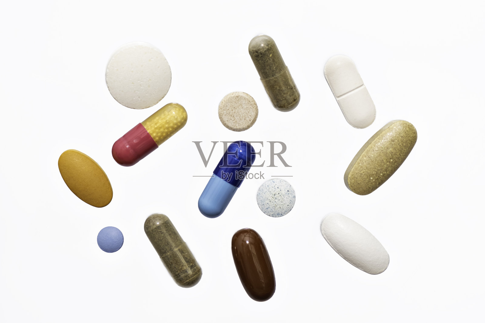 特写彩色粉末软胶囊药丸,维生素,蓝色,粉红色,黄色,棕色的补充在白色的背景照片摄影图片