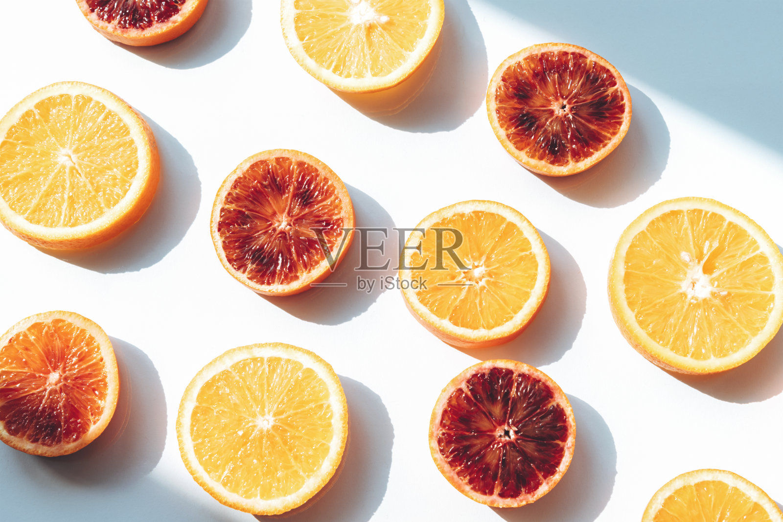 红色和黄色的橙色切片在白色的背景与阴影。纹理、背景照片摄影图片