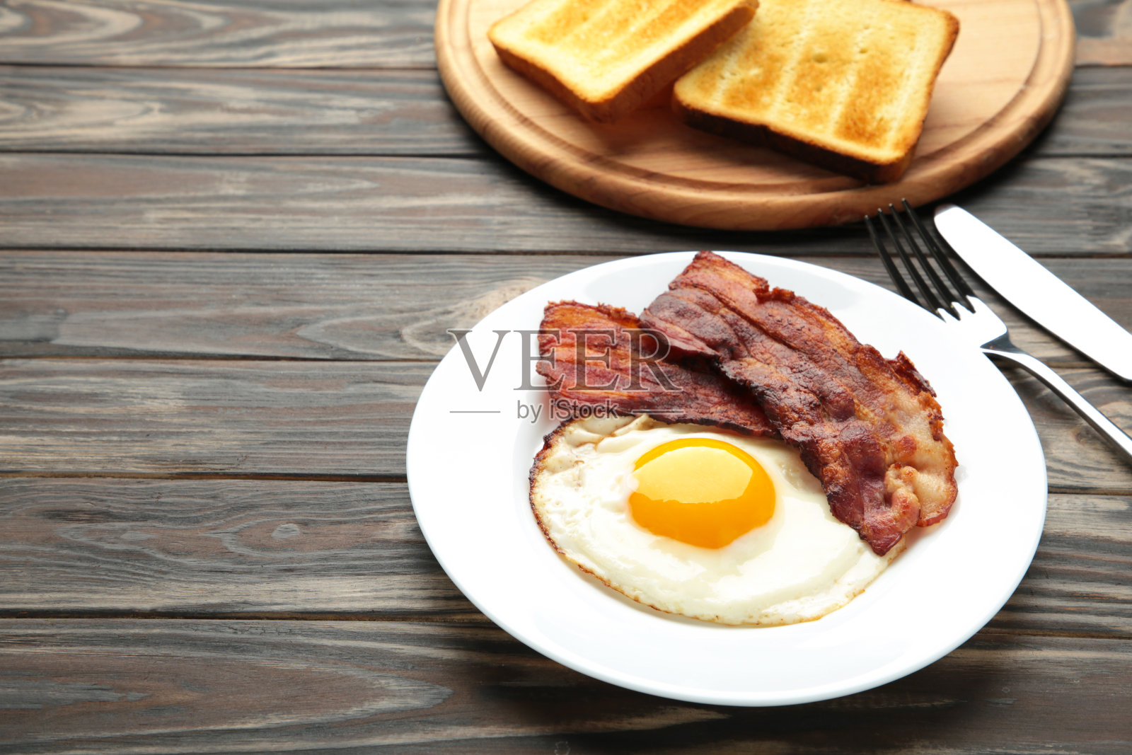 棕色背景的早餐是鸡蛋和培根。与复制空间。照片摄影图片