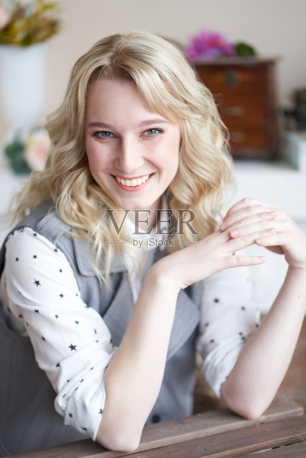 美丽的金发专家坐在桌边,一个女人微笑着照片摄影图片