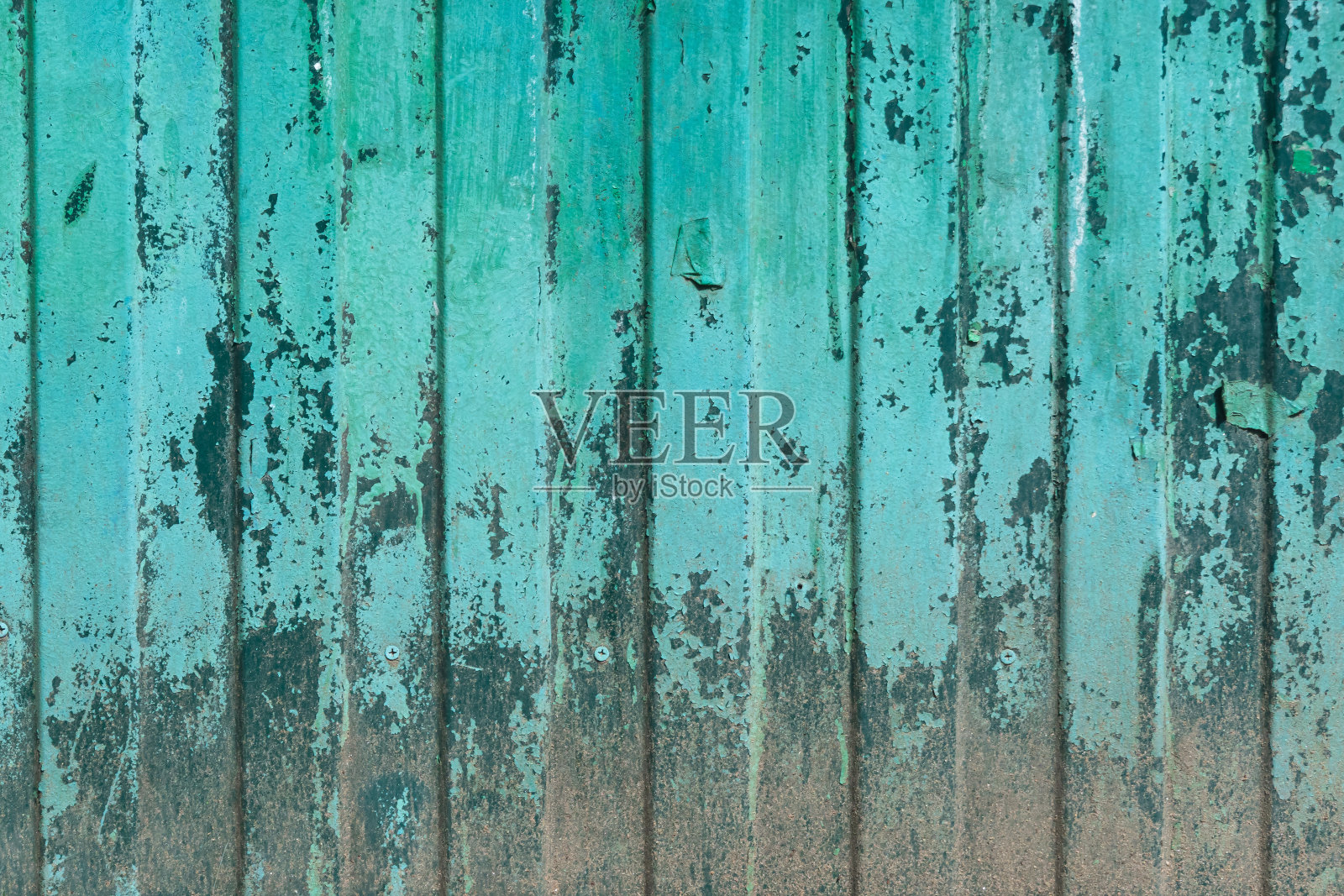 一个旧的绿色篱笆的碎片,由侧面的薄片制成。下半部分有腐蚀,油漆已经垮塌。背景。纹理。照片摄影图片