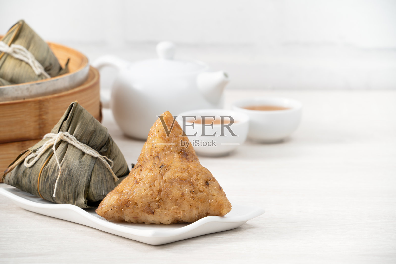 粽子端午节粽子以明亮的木桌为背景。照片摄影图片