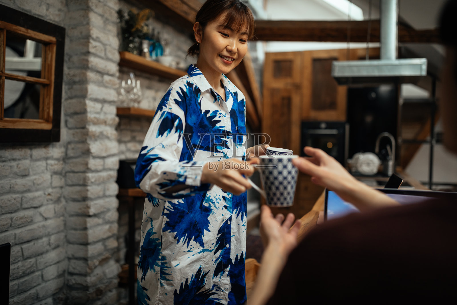 亚洲女人给她男朋友送咖啡照片摄影图片