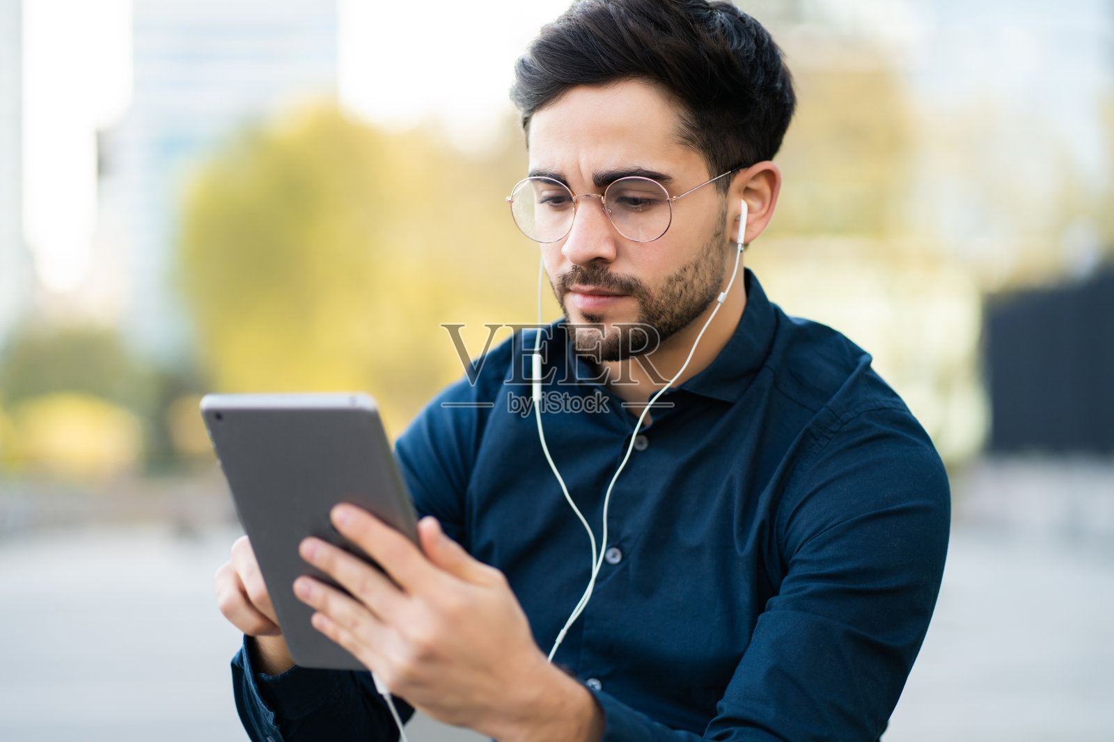 年轻人在户外使用数码平板电脑。照片摄影图片