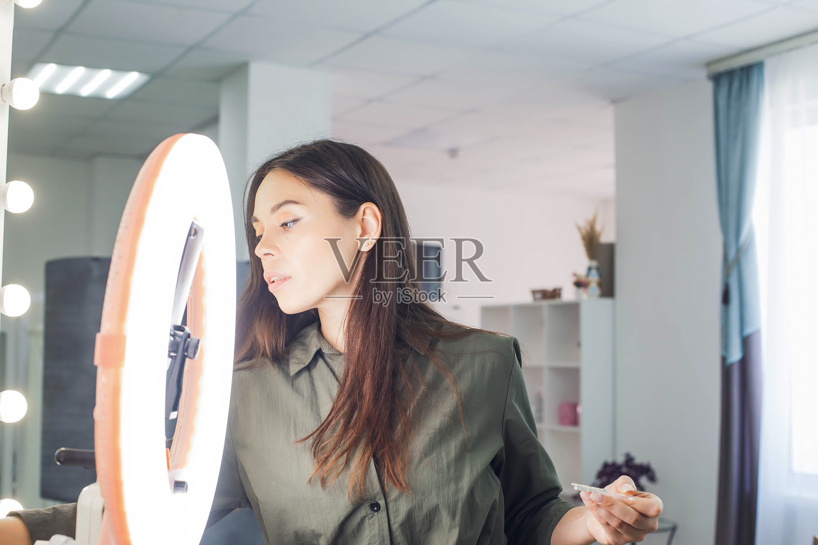 师父在美容院给金发美女化妆照片摄影图片