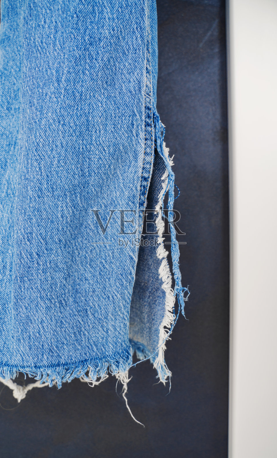 牛仔裤背景旧牛仔图案。垂直视图的经典纹理的破洞牛仔裤裤子。蓝色复古牛仔裤背景照片摄影图片