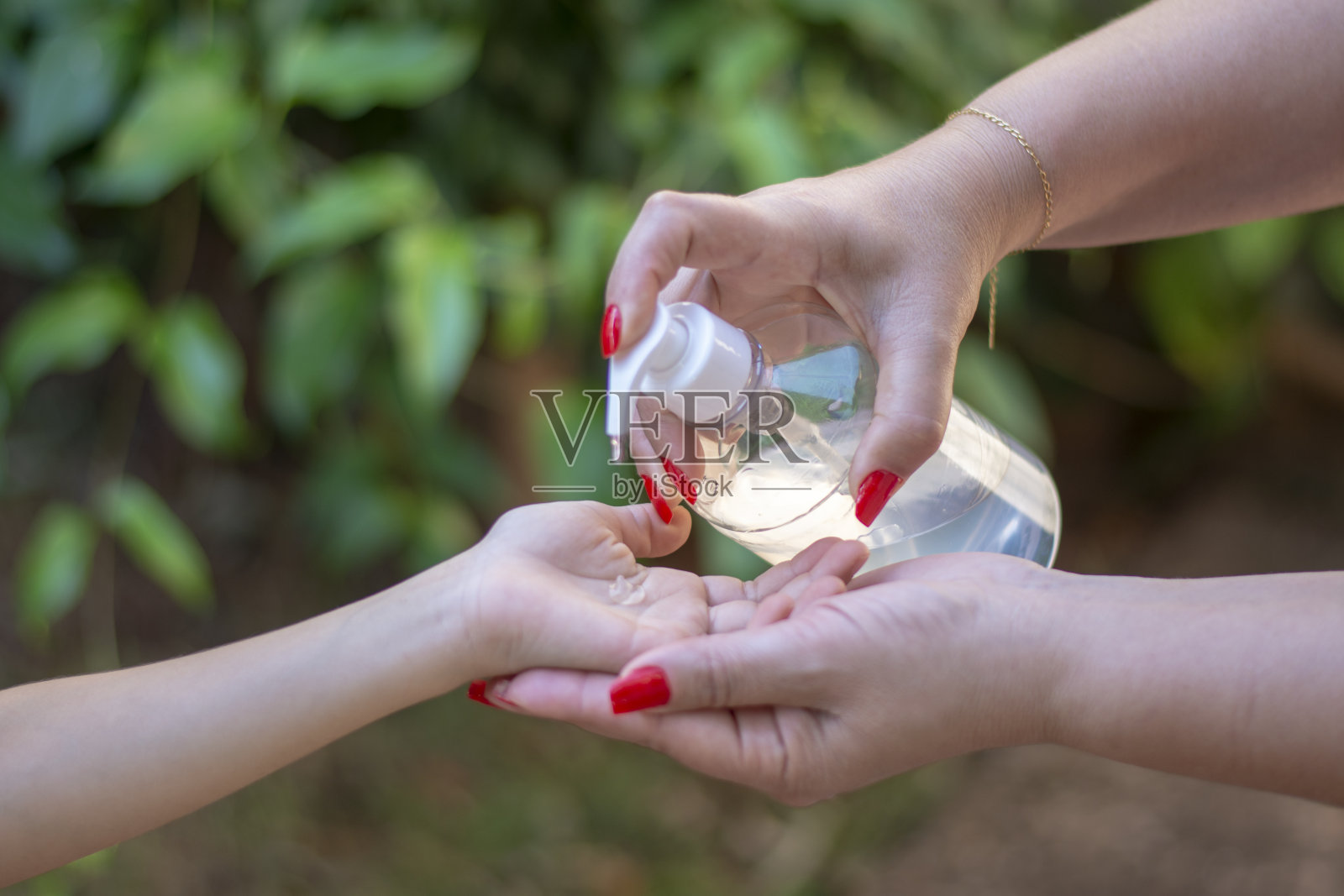 妇女在户外使用抗菌洗手液照片摄影图片
