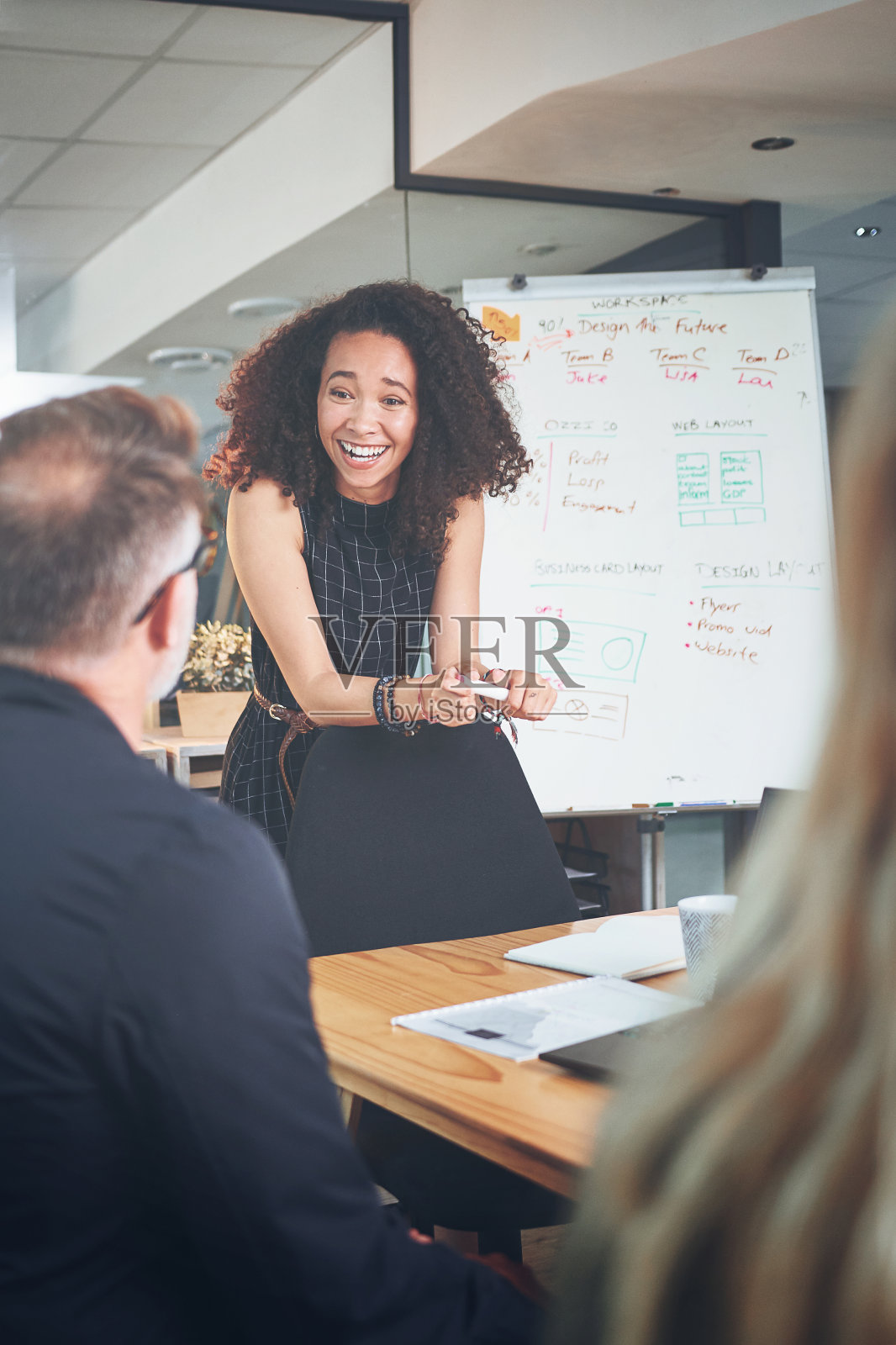 在一间现代办公室的会议室里,一位年轻的女商人正在给她的同事做演示照片摄影图片