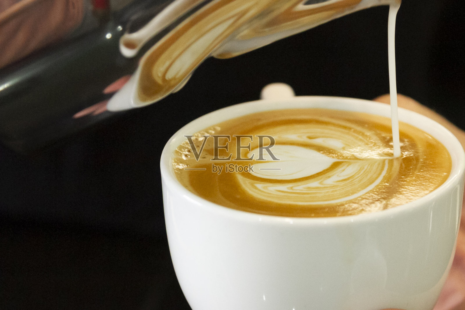 咖啡师的手在咖啡杯上画画照片摄影图片