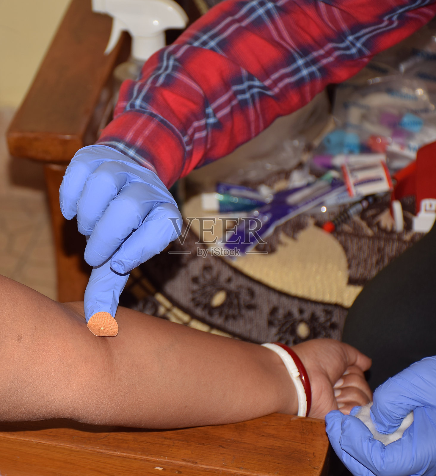 采集血样后,医务代表用粘胶贴在病人手臂上的手照片摄影图片