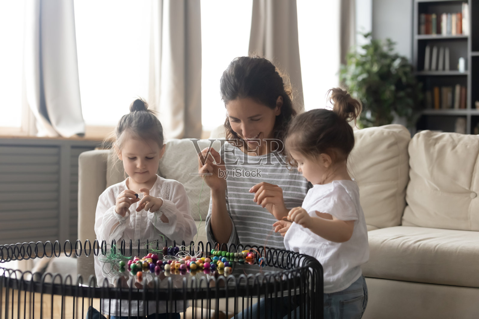 快乐妈妈和小女儿一起做手镯照片摄影图片