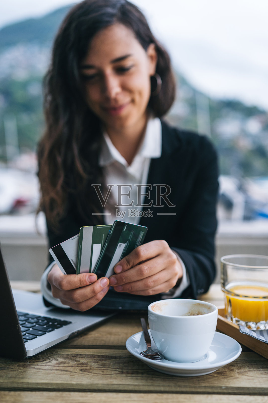 年轻的女商人在户外咖啡馆使用信用卡照片摄影图片