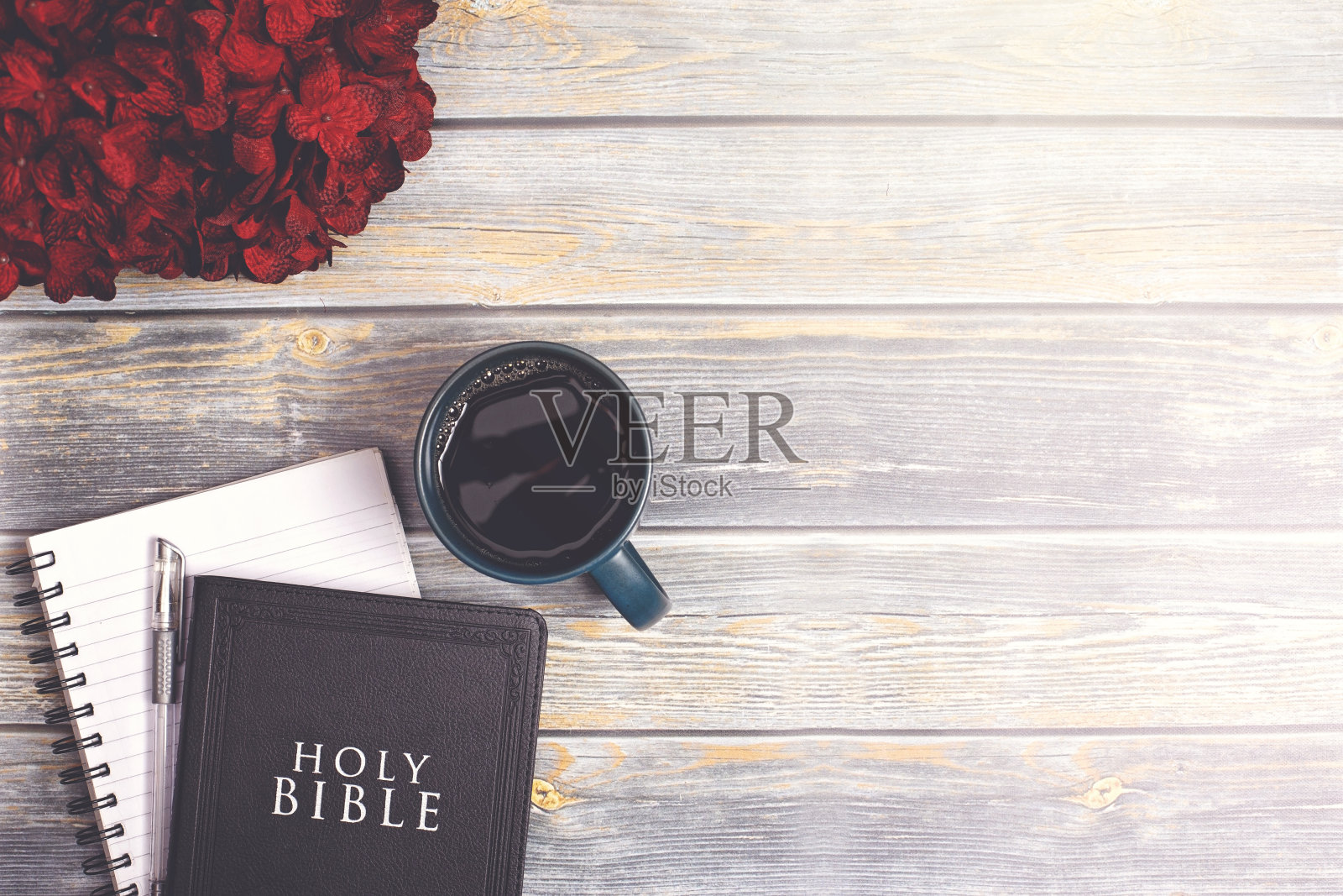 一张破旧的木桌上放着一本圣经和一杯咖啡照片摄影图片