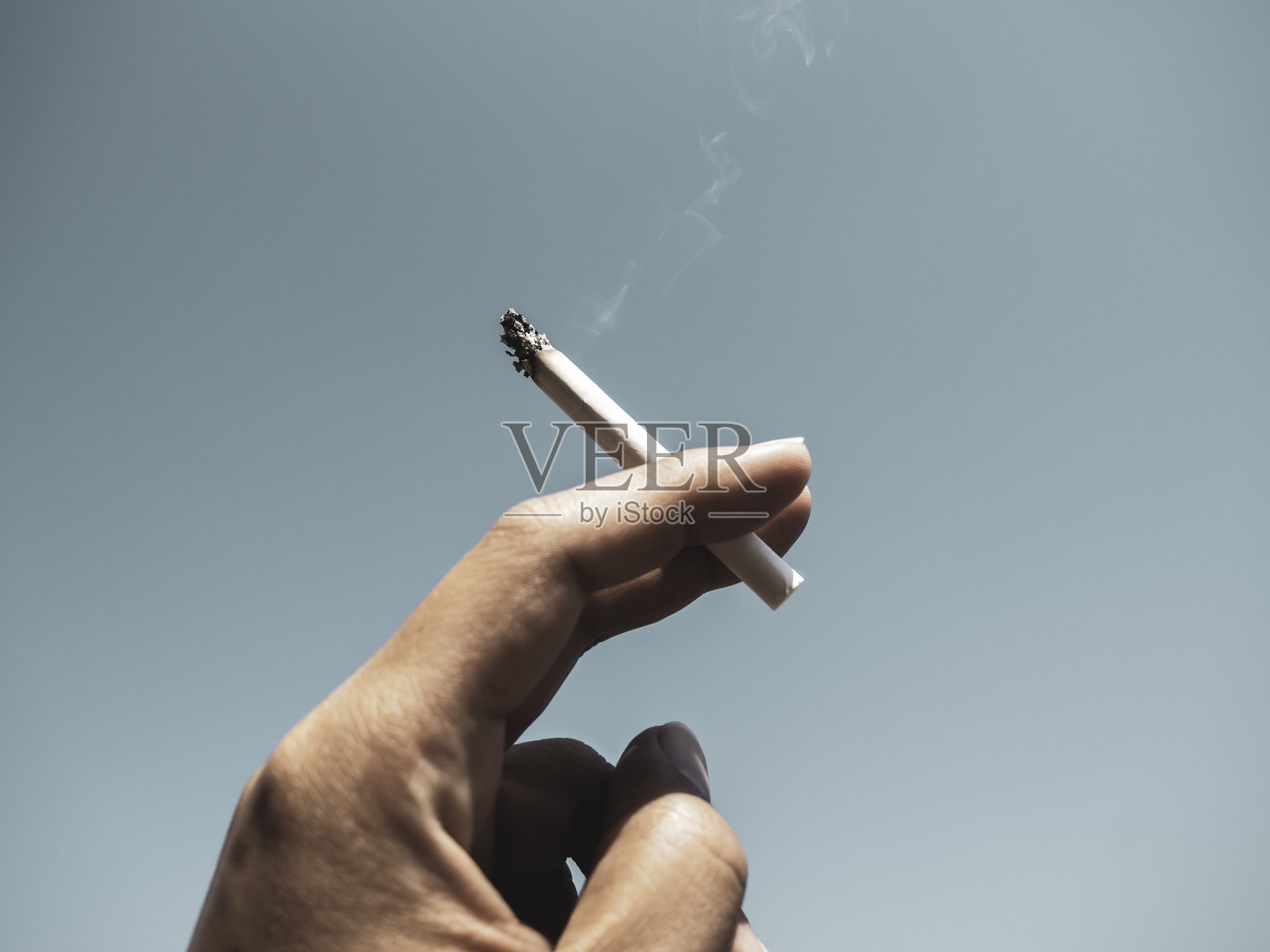 香烟在男人手里随烟抽。照片摄影图片