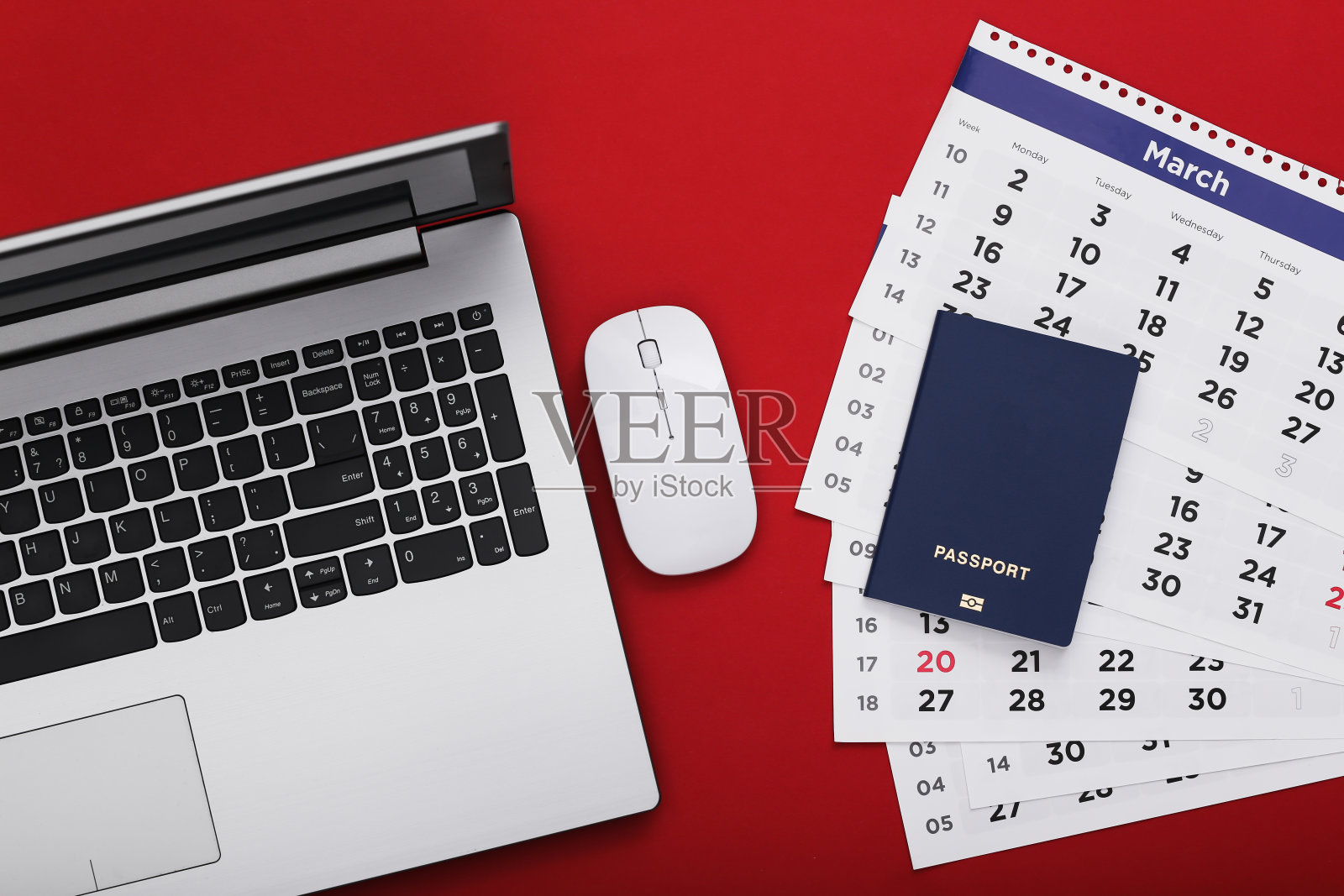 时间旅行。带日历的笔记本电脑,红色背景的护照。前视图。照片摄影图片