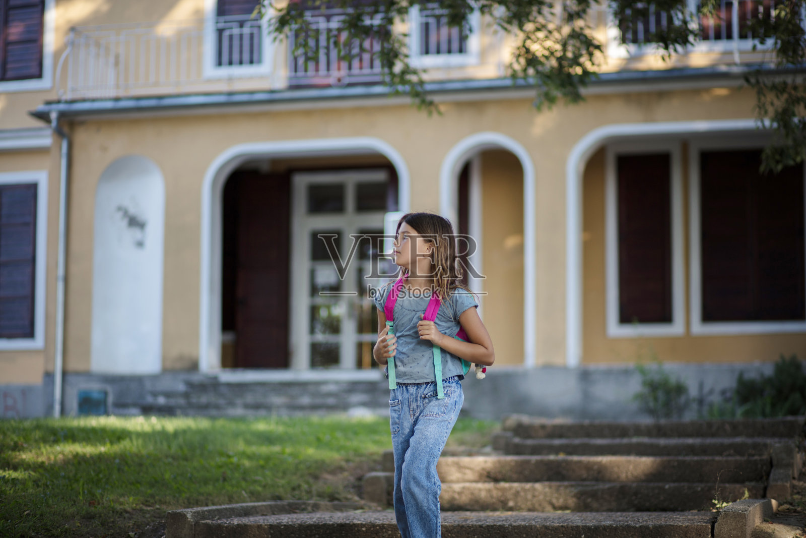 一个正要离开学校的小女孩。照片摄影图片
