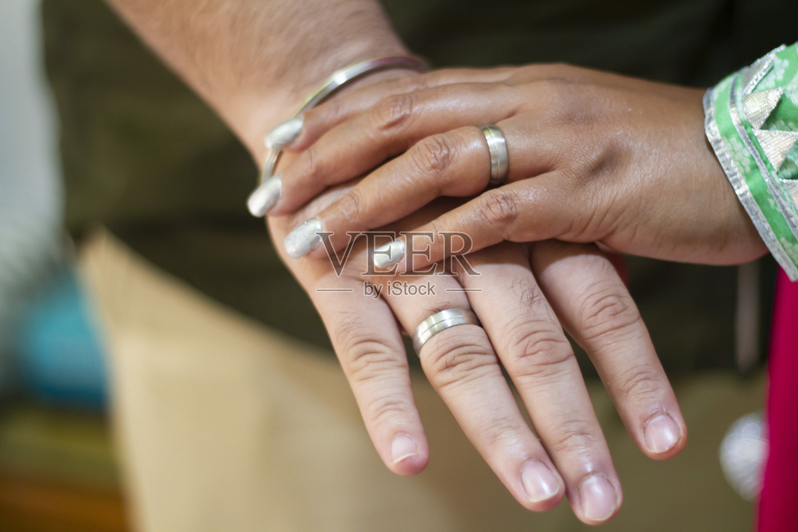 男人和女人戴着结婚戒指的照片。年轻的夫妇手牵着手,婚礼当天的仪式。新婚夫妇的手上戴着结婚戒指。照片摄影图片