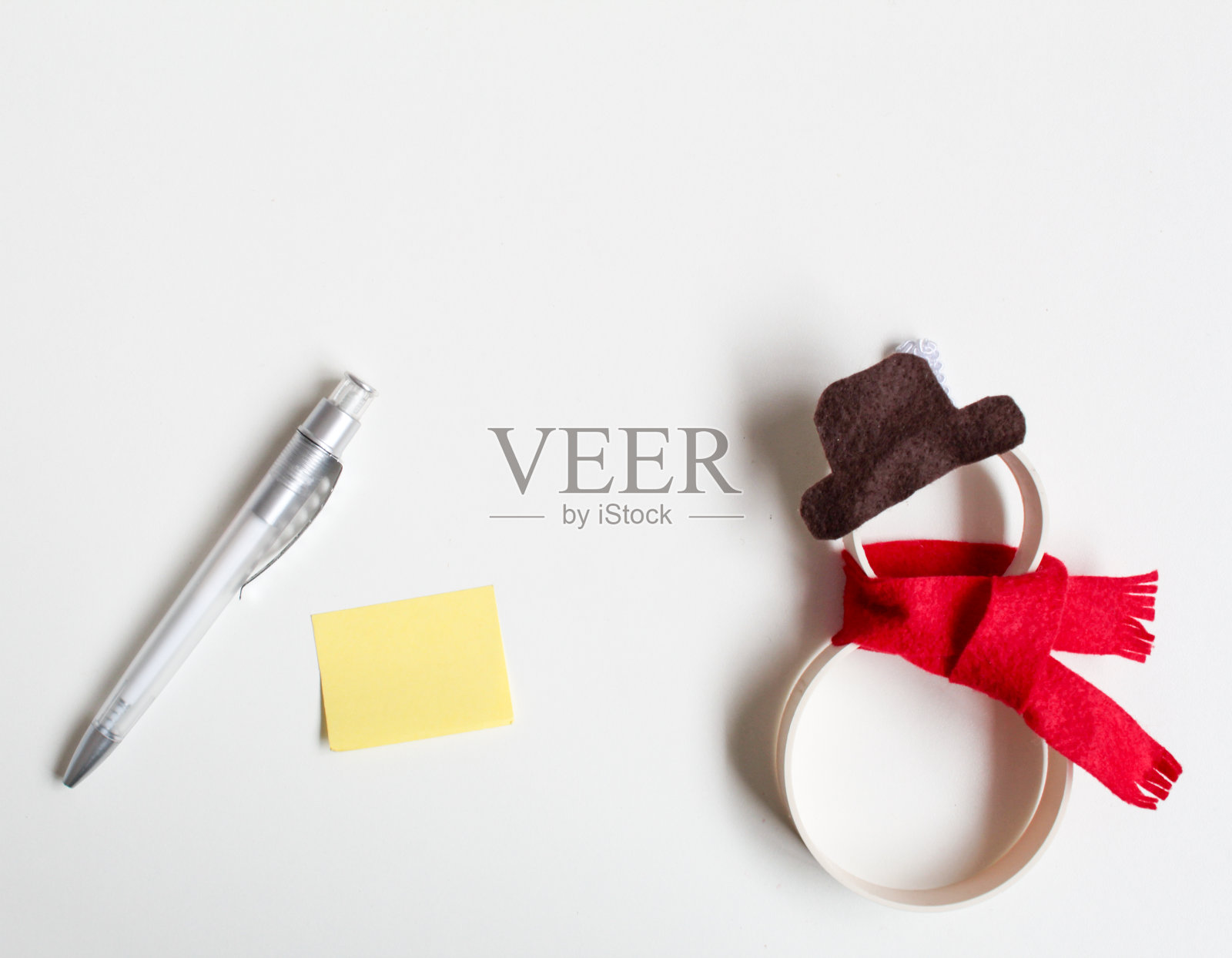 白色背景下戴着帽子和围巾的雪人照片摄影图片