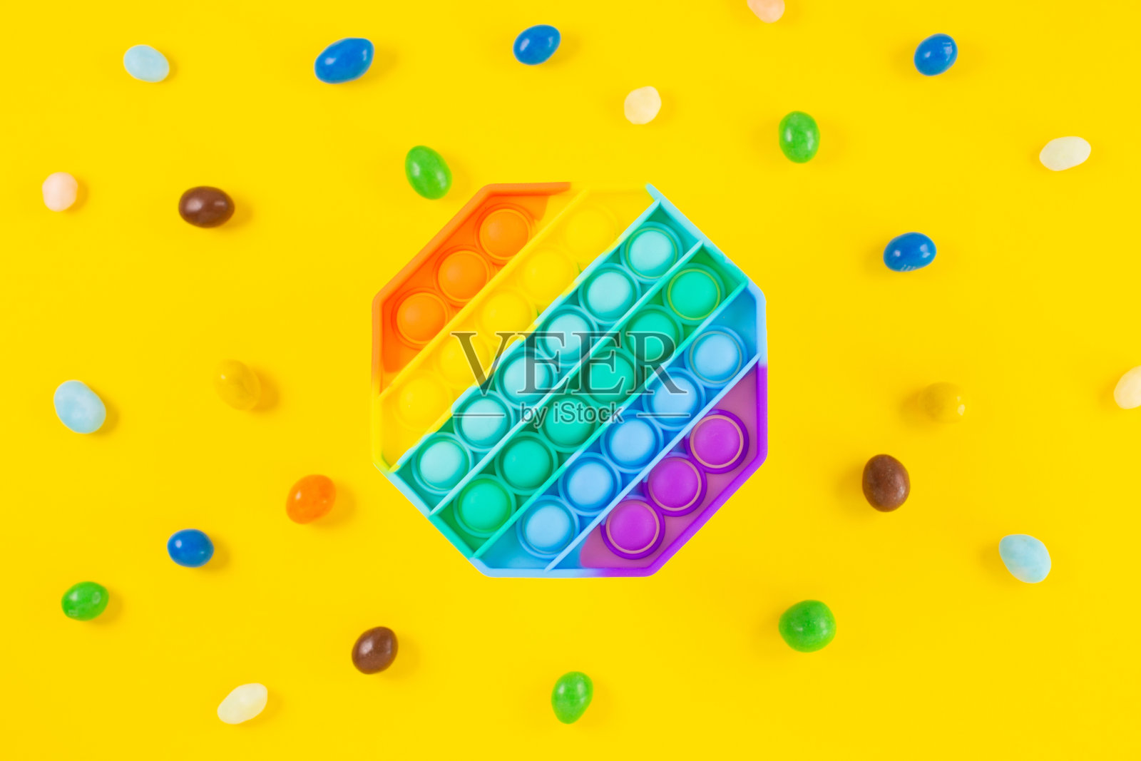 彩虹硅胶感应抗压力弹它玩具周围的彩色糖果照片摄影图片