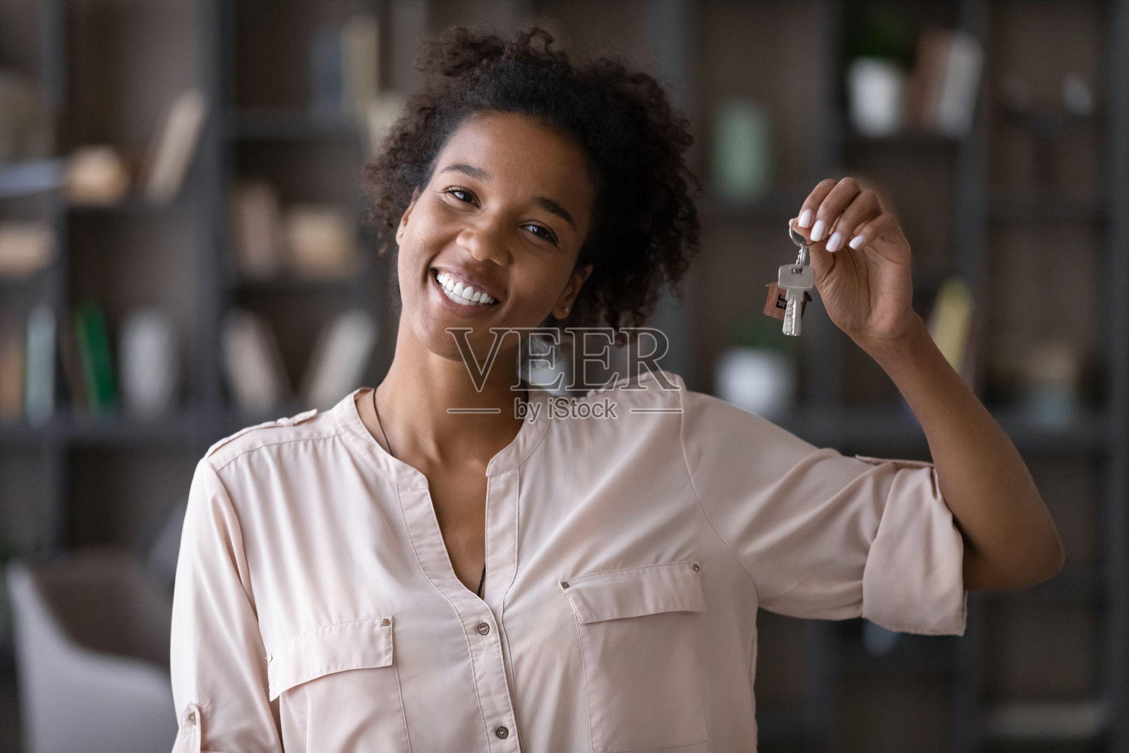 年轻真诚的非洲裔美国妇女展示了相机的钥匙。照片摄影图片