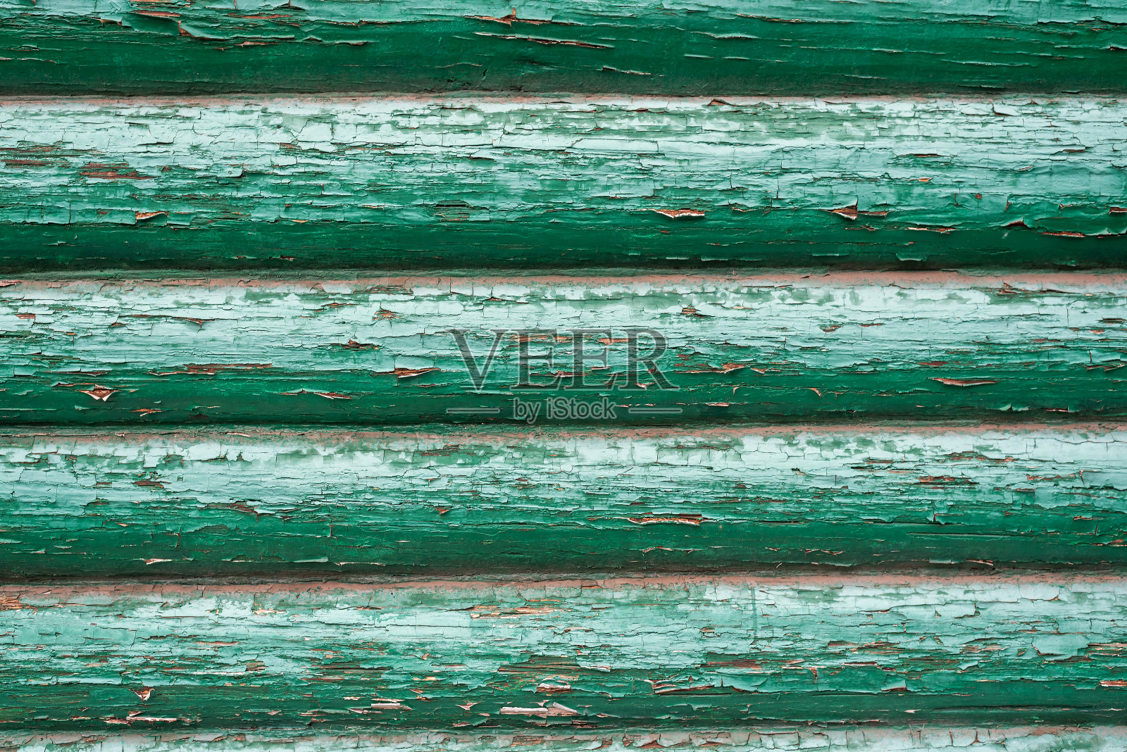 用原木砌成的旧墙上涂满了绿色的油漆剥落照片摄影图片