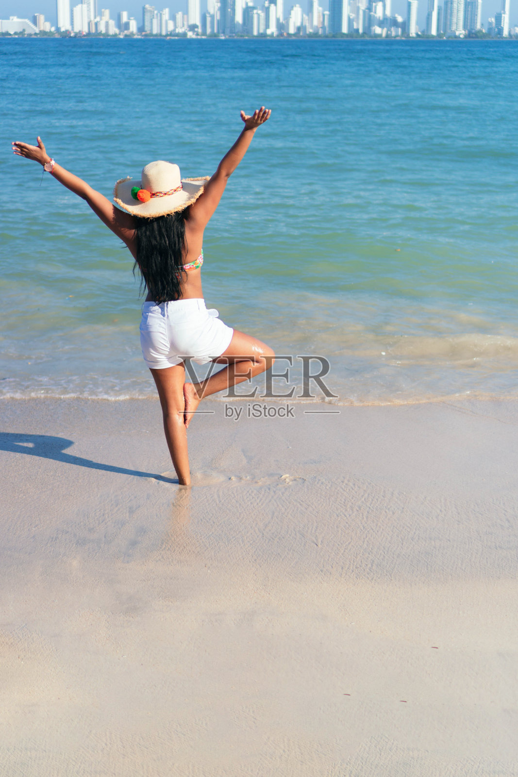 一个高举双手站在大海前的女人照片摄影图片