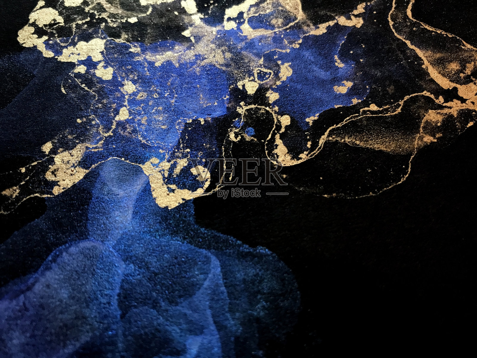 金色和蓝色油漆流体艺术上的黑色背景。星云星系闪抽象画。石头纹理。照片摄影图片